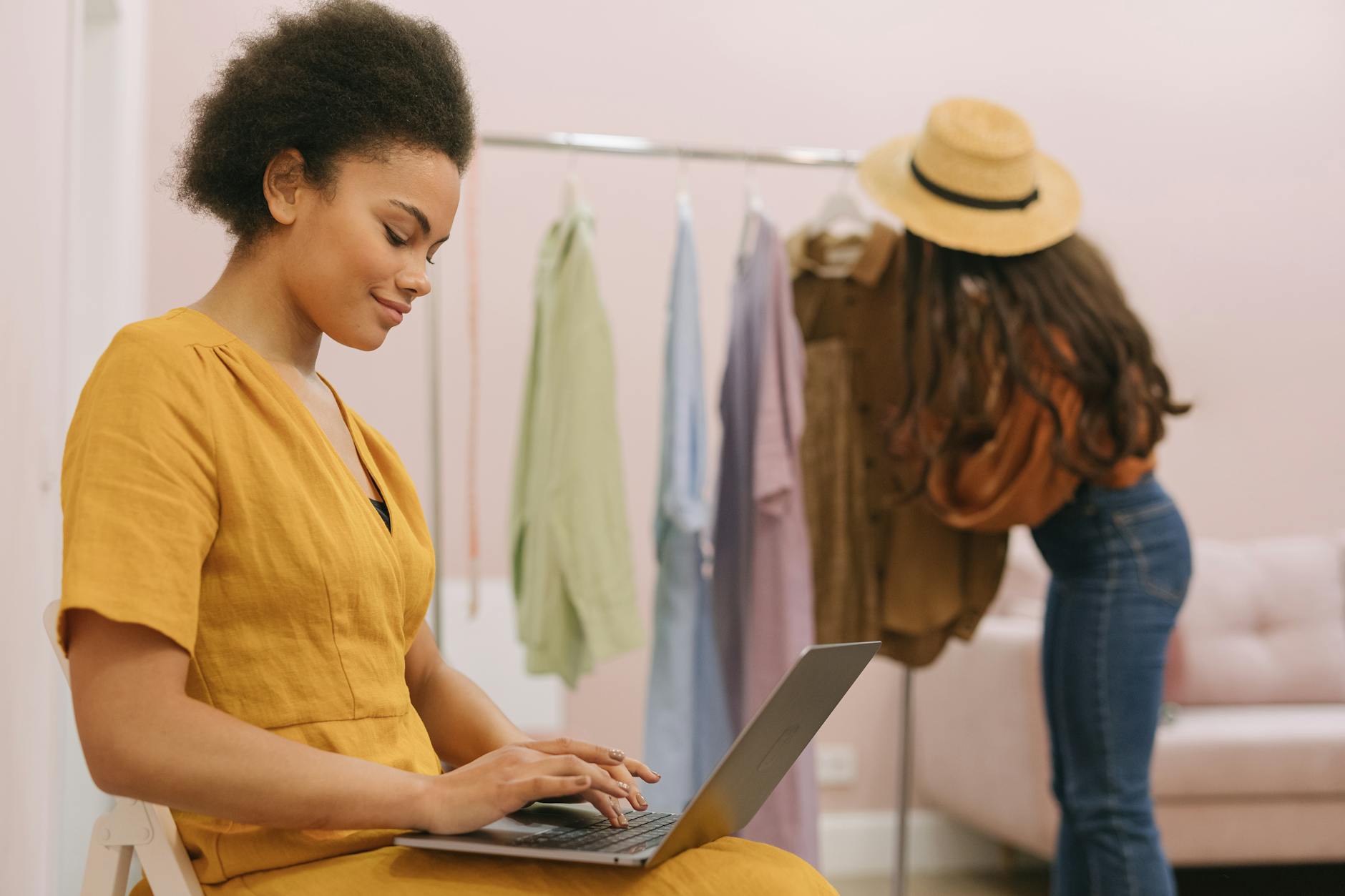 a woman in yellow dress sitting while using her laptop