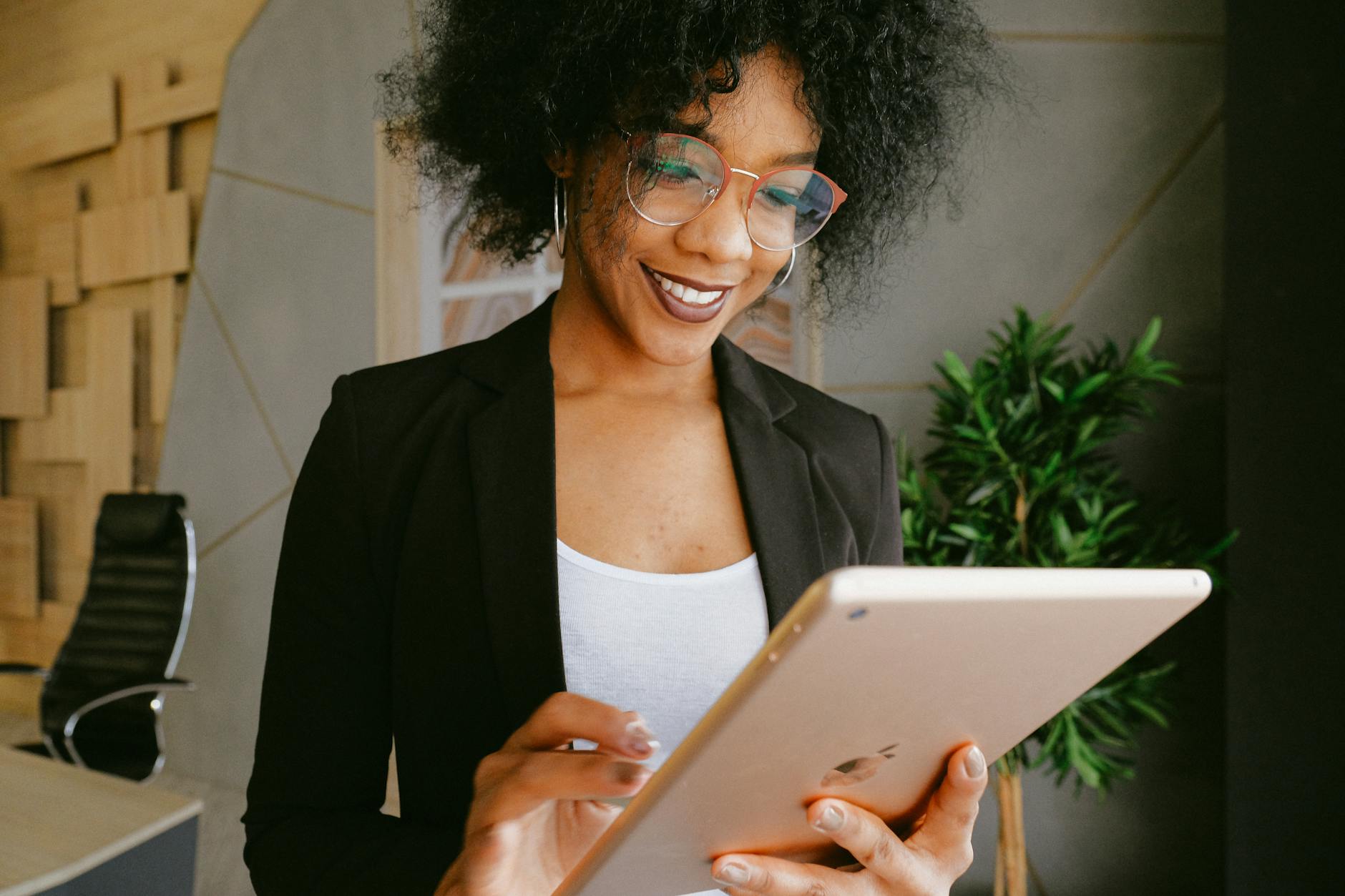 woman in black blazer holding an ipad
