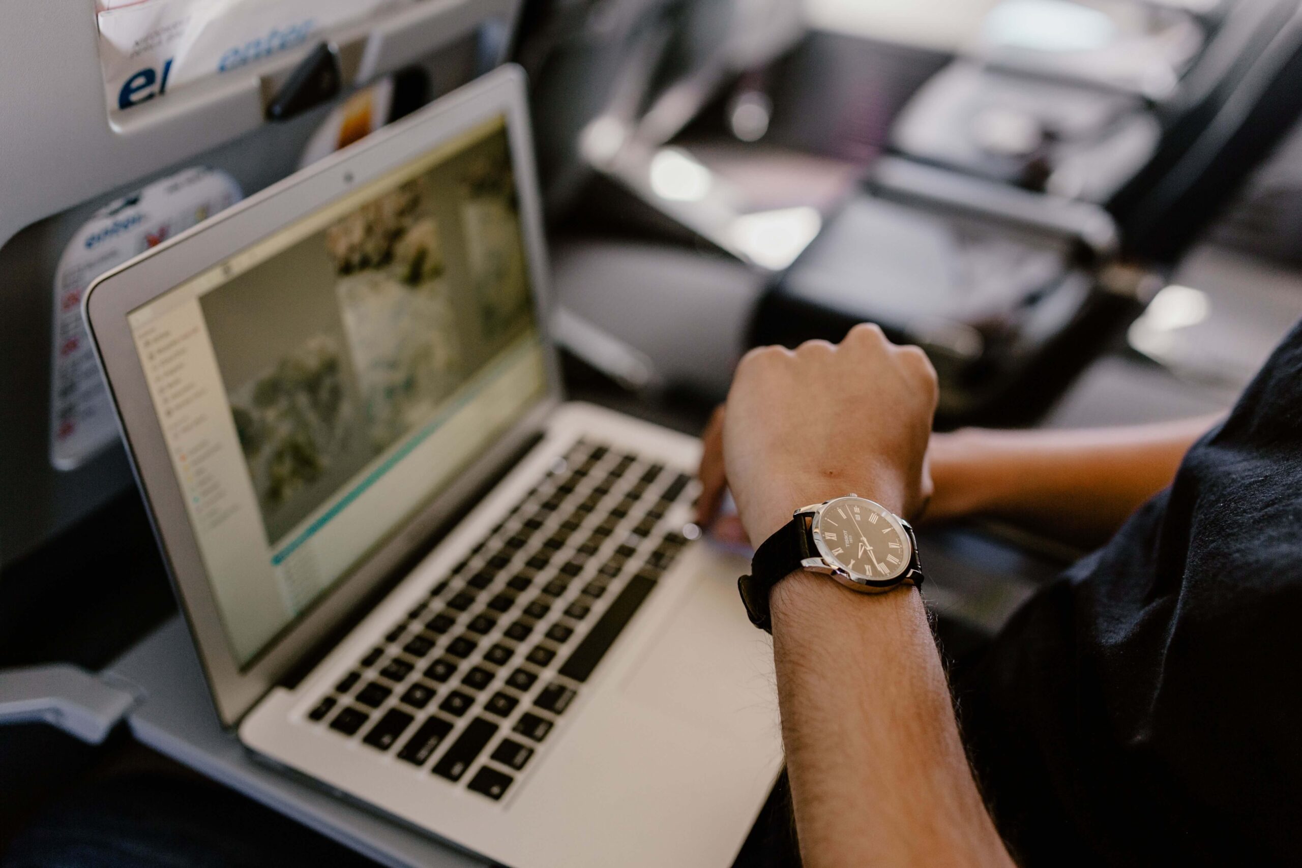 man with notebook sitting inside an airplane looking at watch - 401k rules vesting and testing