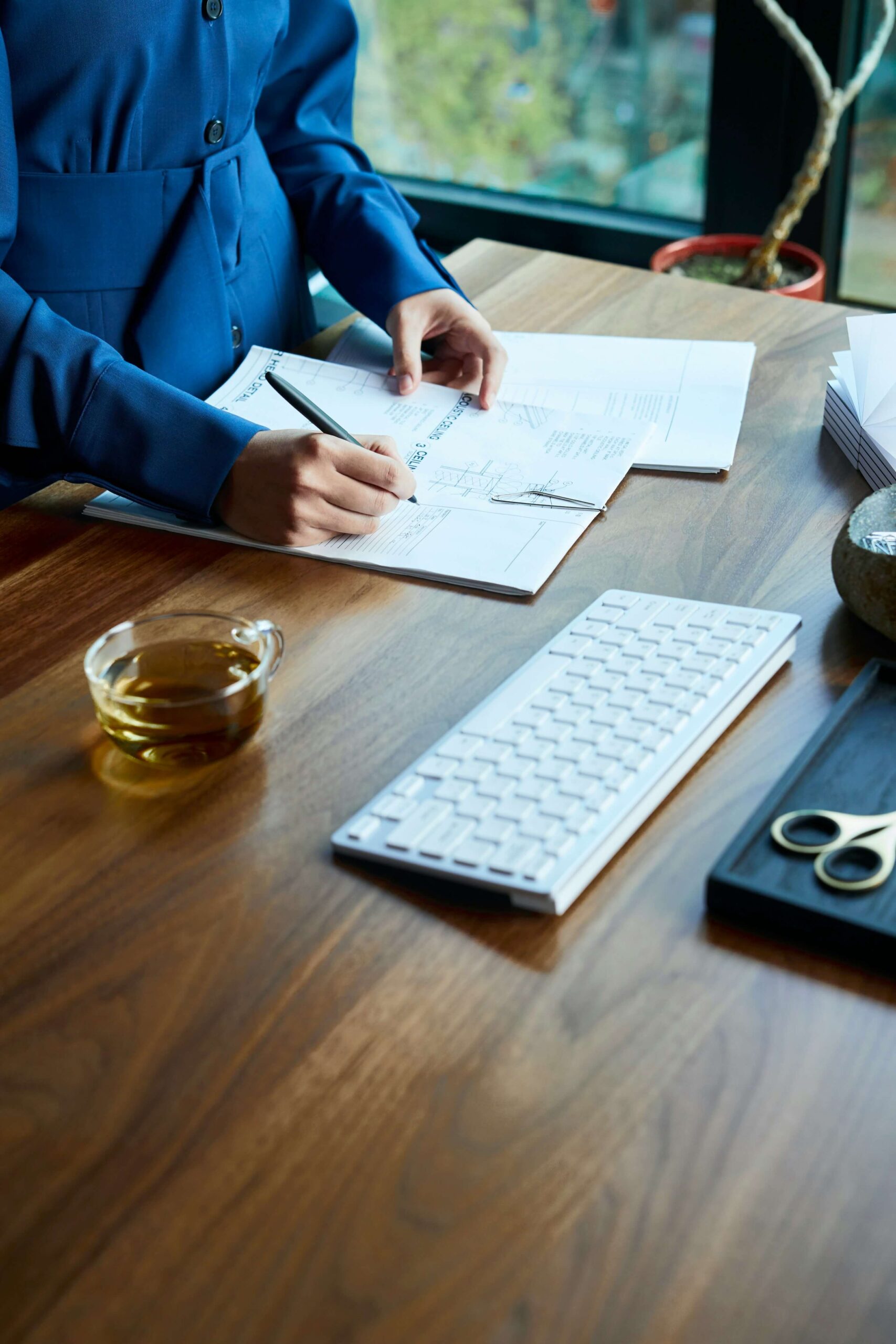 a woman sitting at a desk with a keyboard and papers - PPA restatement deadline