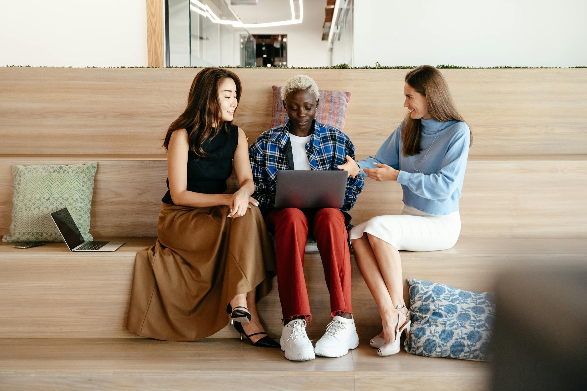 diverse women talking while using laptop